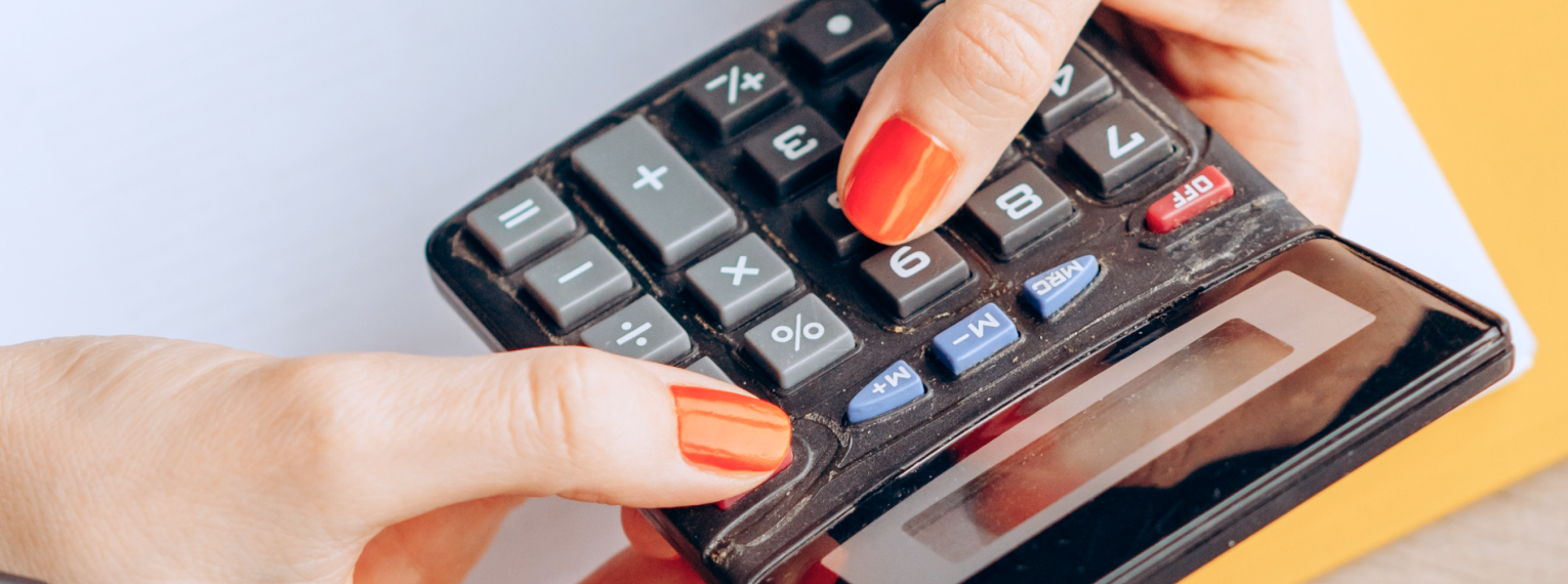 Eine Frau rechnet die Kosten ihrer Zahnzusatzversicherung auf einem Taschenrechner nach.