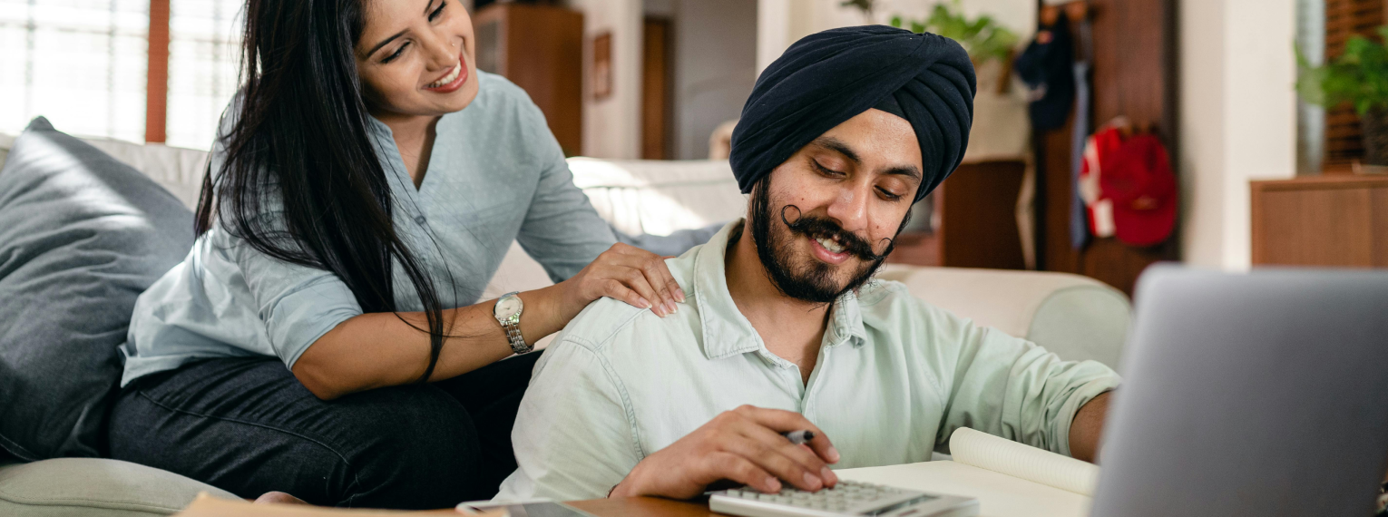 Ein Paar nutzt einen Taschenrechner um mehrere Zahnzusatzversicherungen zu vergleichen.