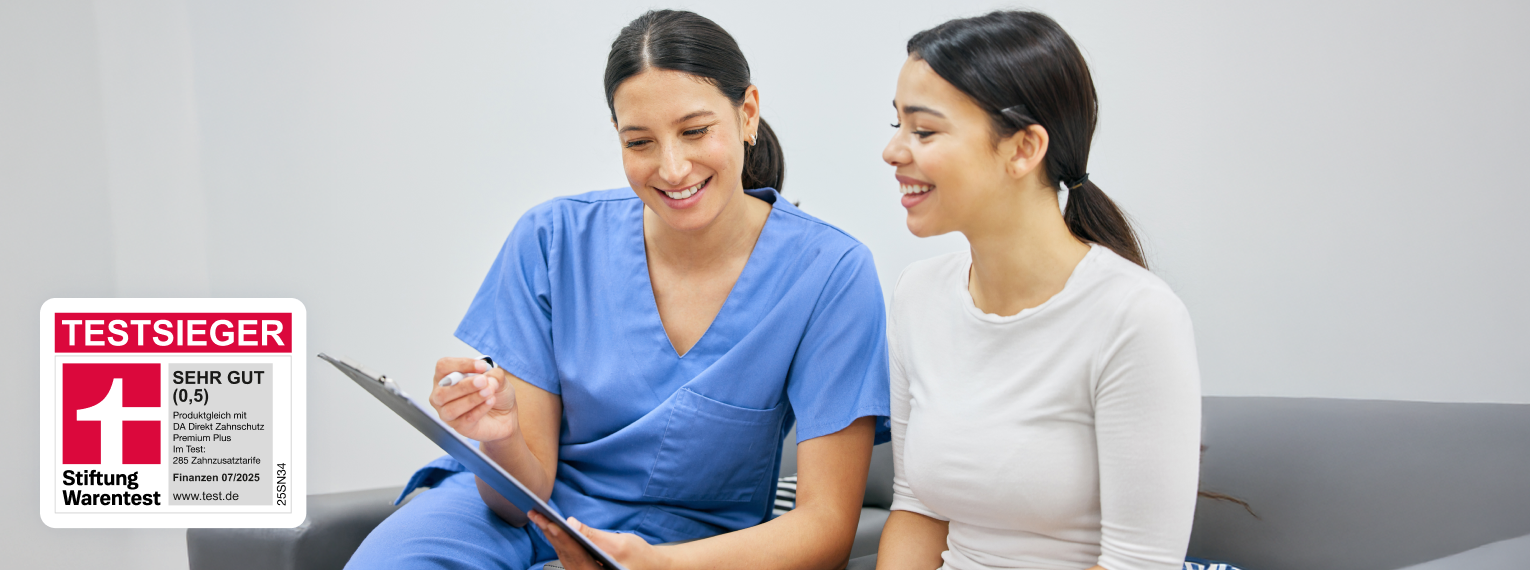 Eine Zahnärztin zeigt und erklärt einer Patientin ein Dokument.