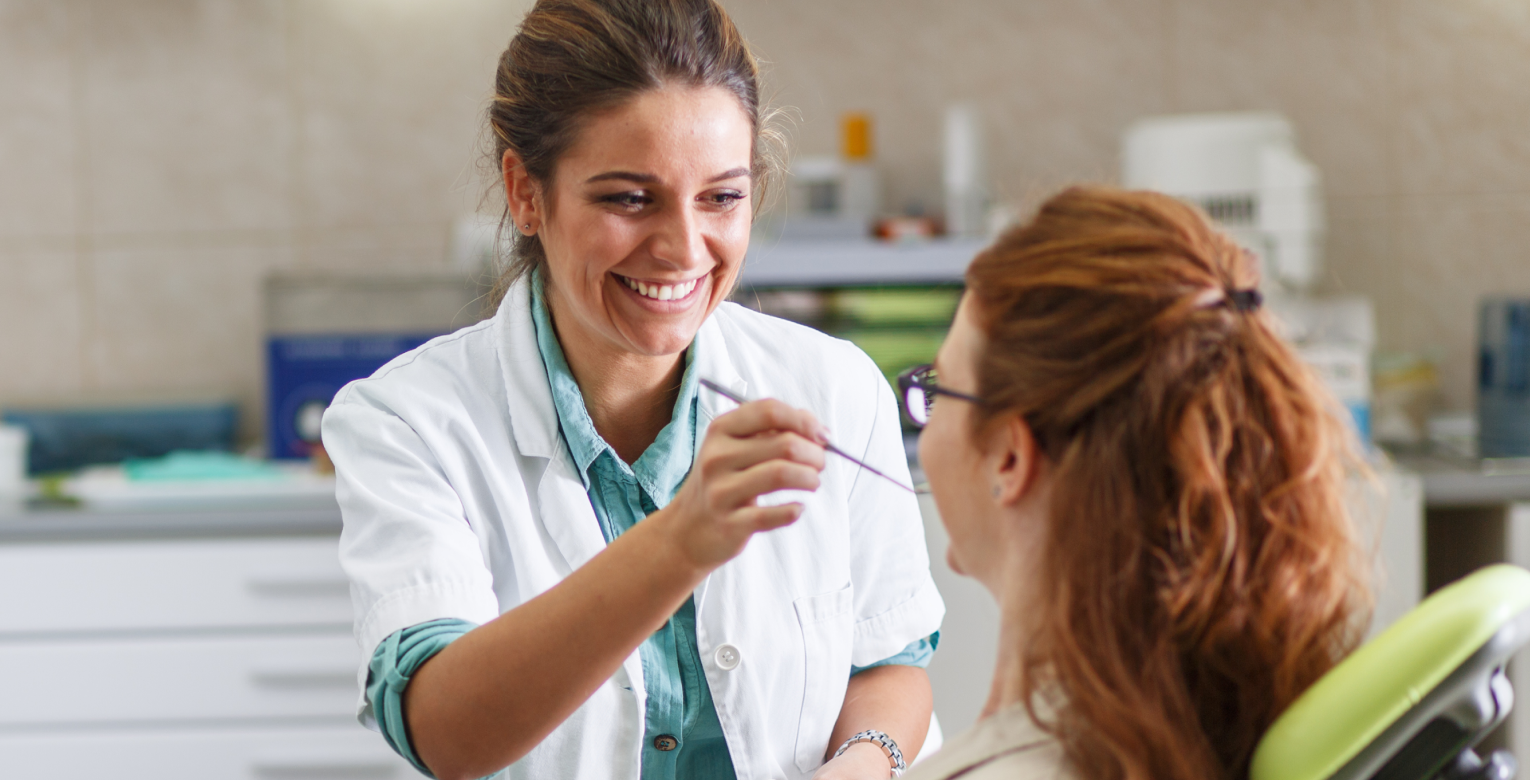 Eine Patientin wird von einer Zahnärztin untersucht.