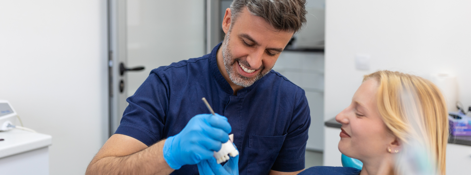 Eine Patientin lächelt ihren Zahnarzt an.