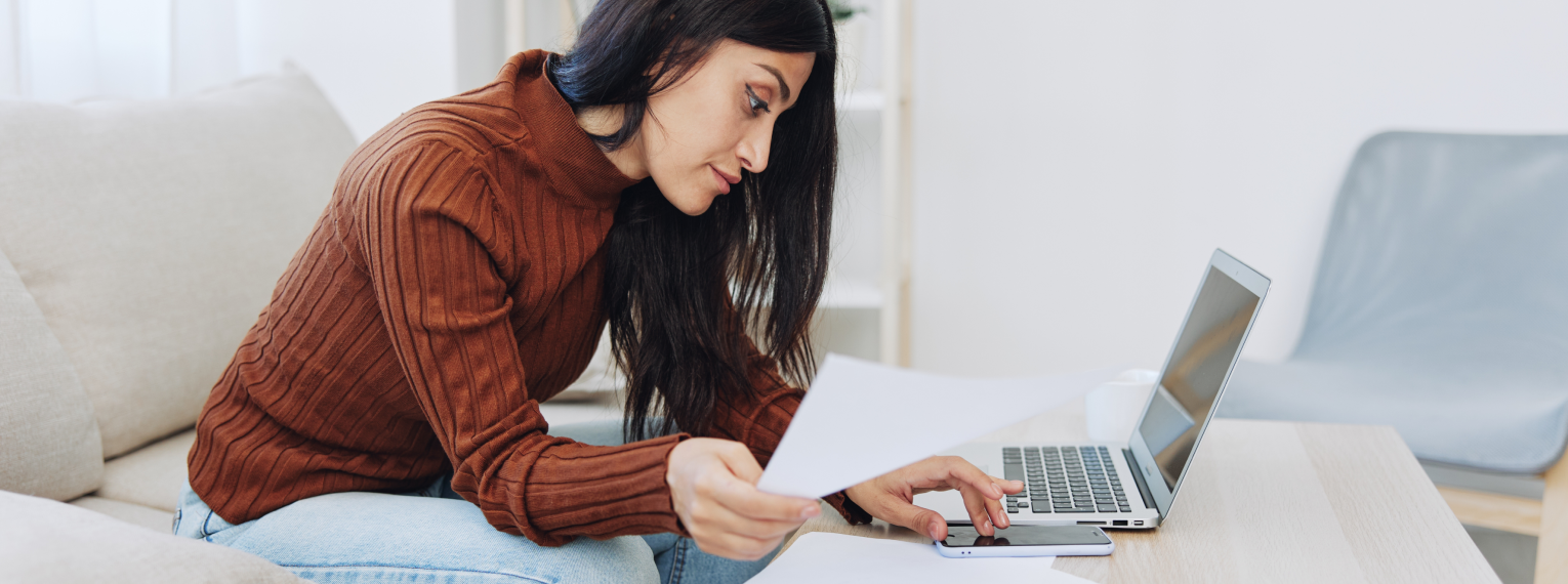Eine Frau vergleicht Zahnzusatzversicherungen mit Zahnstaffel an ihrem Laptop.