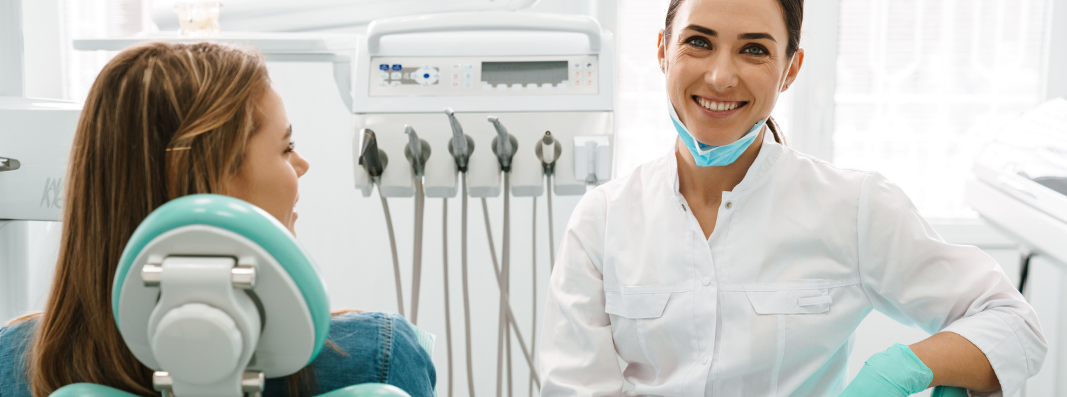 Eine Zahnärztin lächelt ihre Patientin an