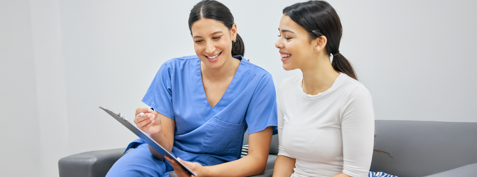 Eine Zahnärztin überprüft mit ihrer Patientin eine Zahnarztrechnung.