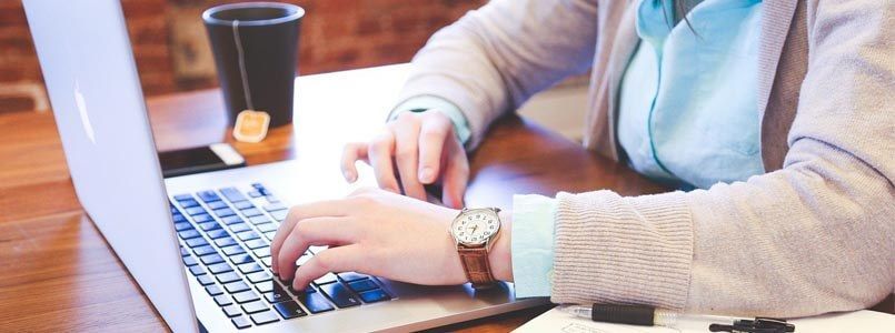 Zu sehen ist ein Mann am Laptop, der recherchiert, ob er unter die Regelung für den Härtefall bei Zahnersatz fällt.