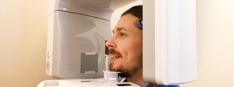 Ein Patient wird beim Zahnarzt geröntgt, um die Ursache von Kieferschmerzen zu untersuchen.