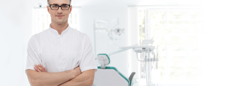 Zu sehen ist ein Zahnarzt, der in seiner Praxis eine Wurzelbehandlung durchführt.