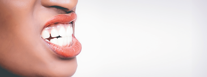 Eine Patientin zeigt ihrem Zahnarzt ihre schiefen Zähne.