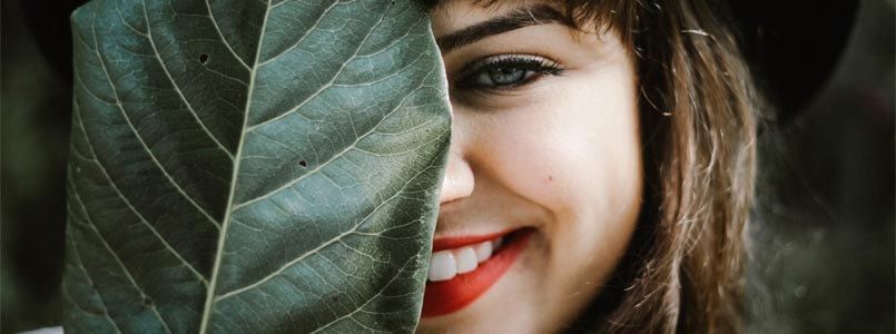 Zu sehen ist eine Frau mit einem strahlenden Lächeln und gesundem Zahnschmelz.
