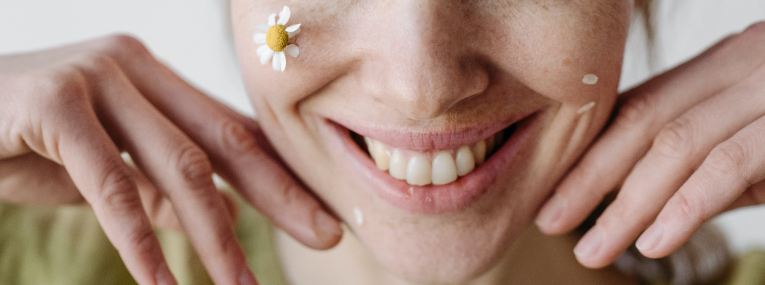 Eine Frau lächelt und fragt sich, was Ihre Zähne über Ihre Persönlichkeit verraten.
