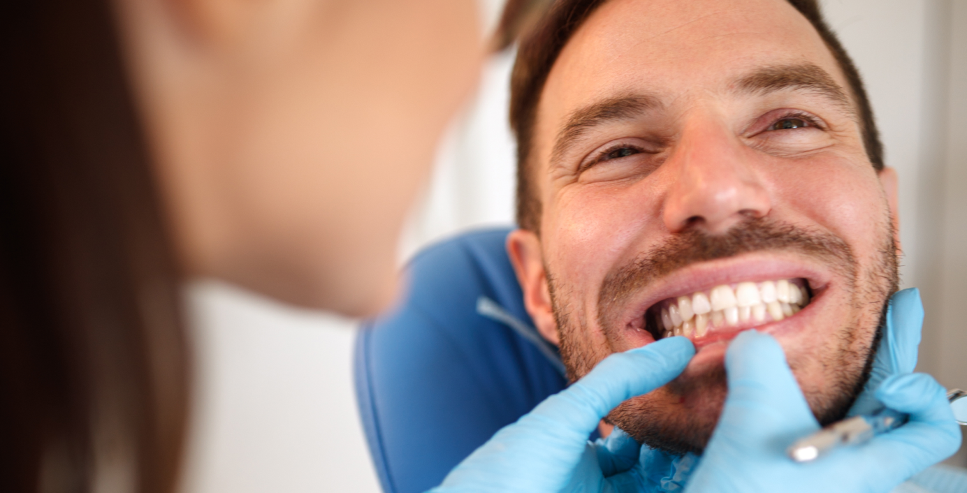 Eine Zahnärztin untersucht die Zähne eines Patientens.