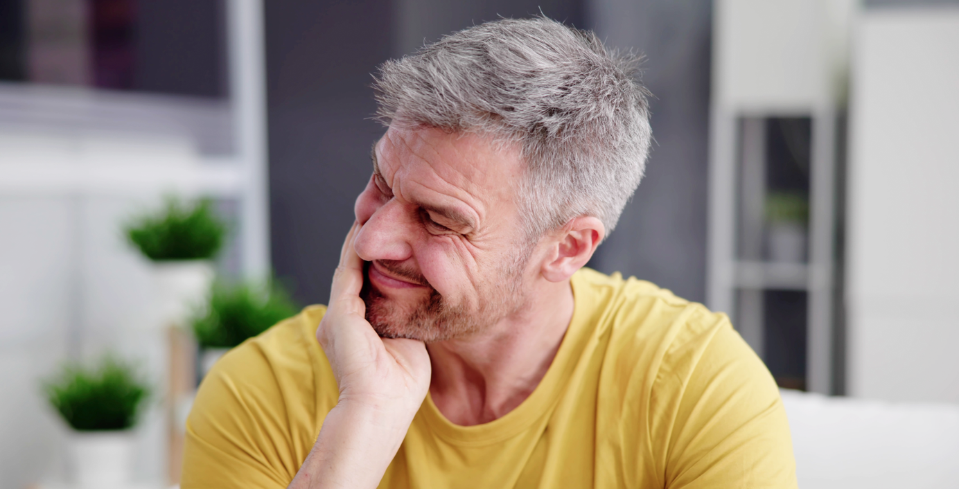 Ein Mann hat starke Kieferschmerzen wegen CMD.