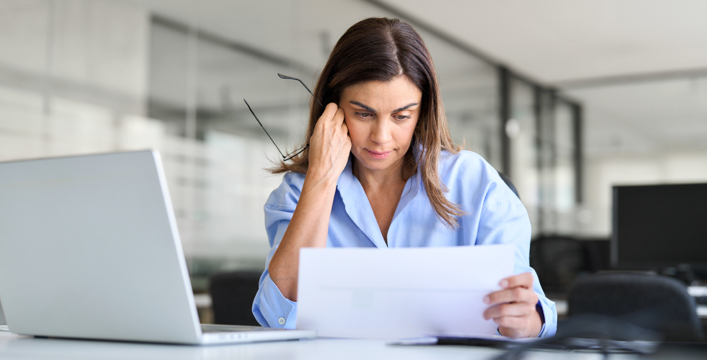 Eine Frau schaut sich ihre Zahnarztrechnung an.