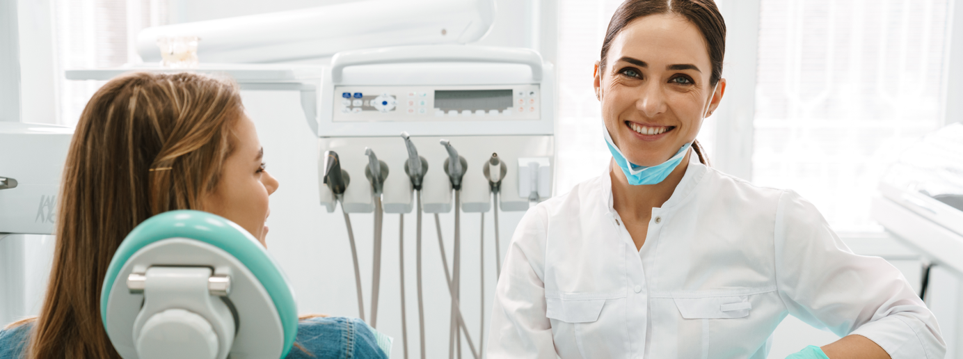 Eine Patientin liegt im Behandlungsstuhl neben einer Zahnärztin.