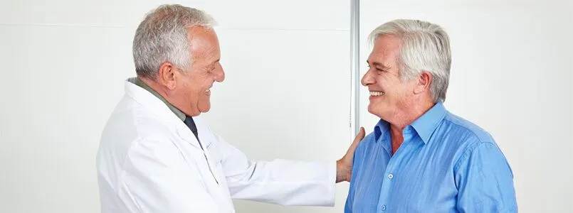 Ein Zahnarzt berät einen Patienten zum Knochenaufbau im Oberkiefer durch einen Sinuslift.