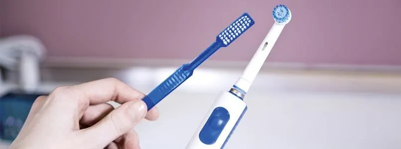 Ein Patient fragt sich, ob eine elektrische Zahnbürste wirklich besser ist als eine Handzahnbürste.