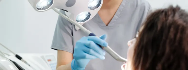 Zu sehen ist eine Patientin, der Zahnstein entfernt wird.