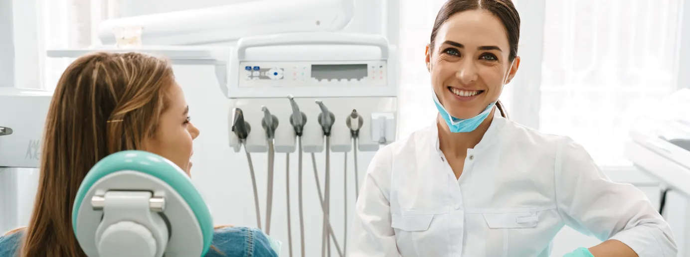 Eine Patientin liegt im Behandlungsstuhl neben einer Zahnärztin.