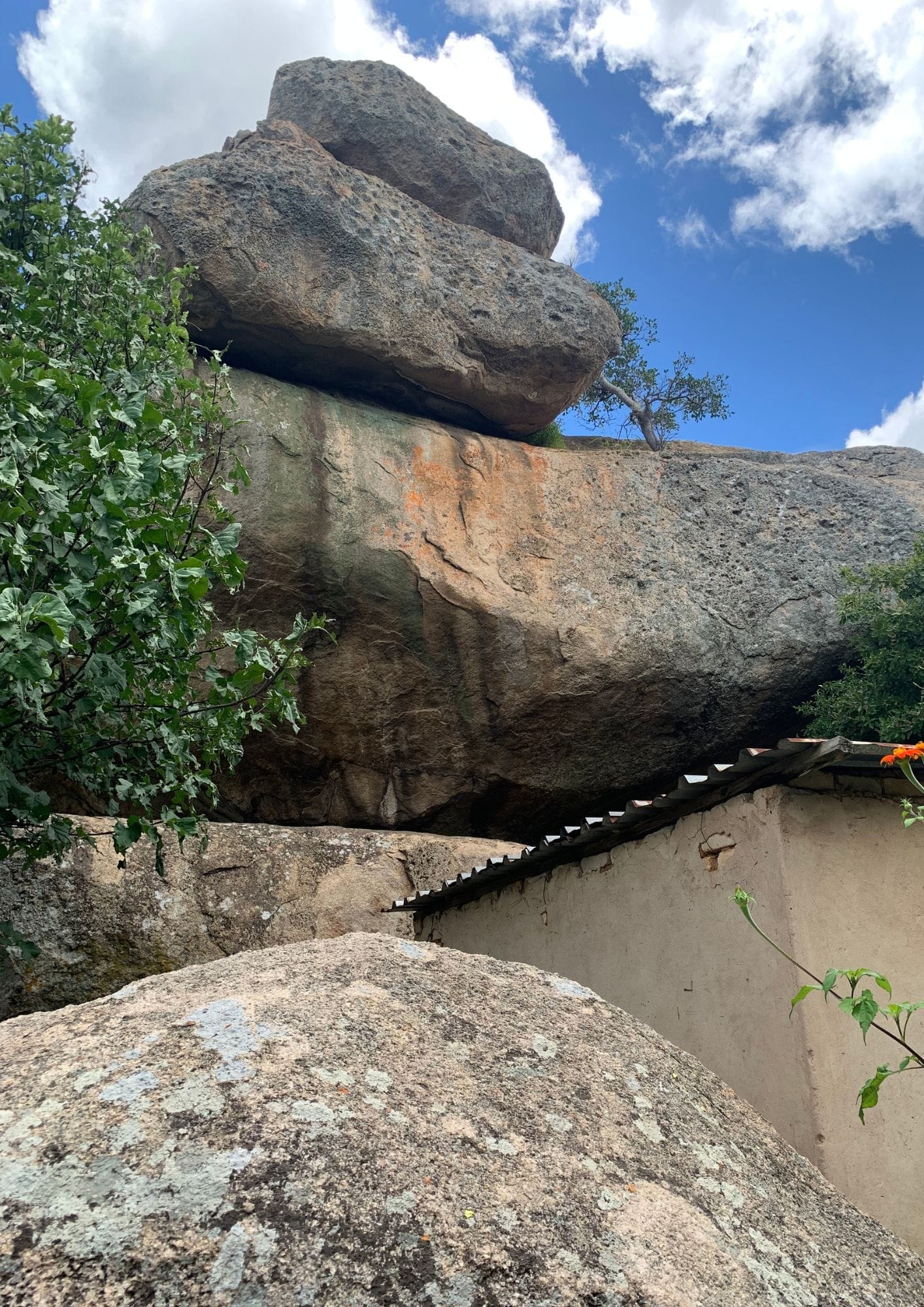 A large rocks and a building

AI-generated content may be incorrect.