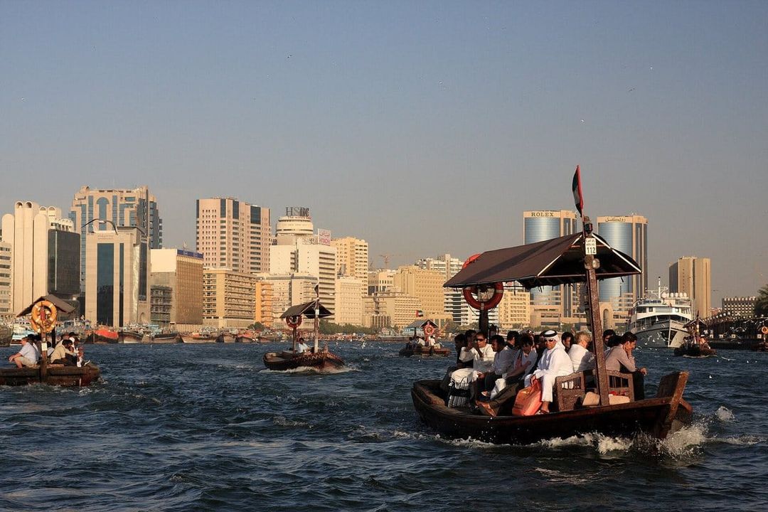 Abras, las barcas tradicionales de madera, cruzan el Dubai Creek frente a los edificios de oficinas de Deira.