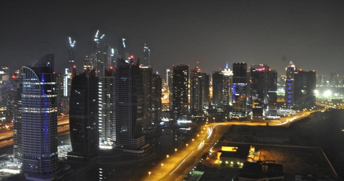 Jumeirah Lakes Towers in Dubai lit up at night, the district that is home to the DMCC free zone.