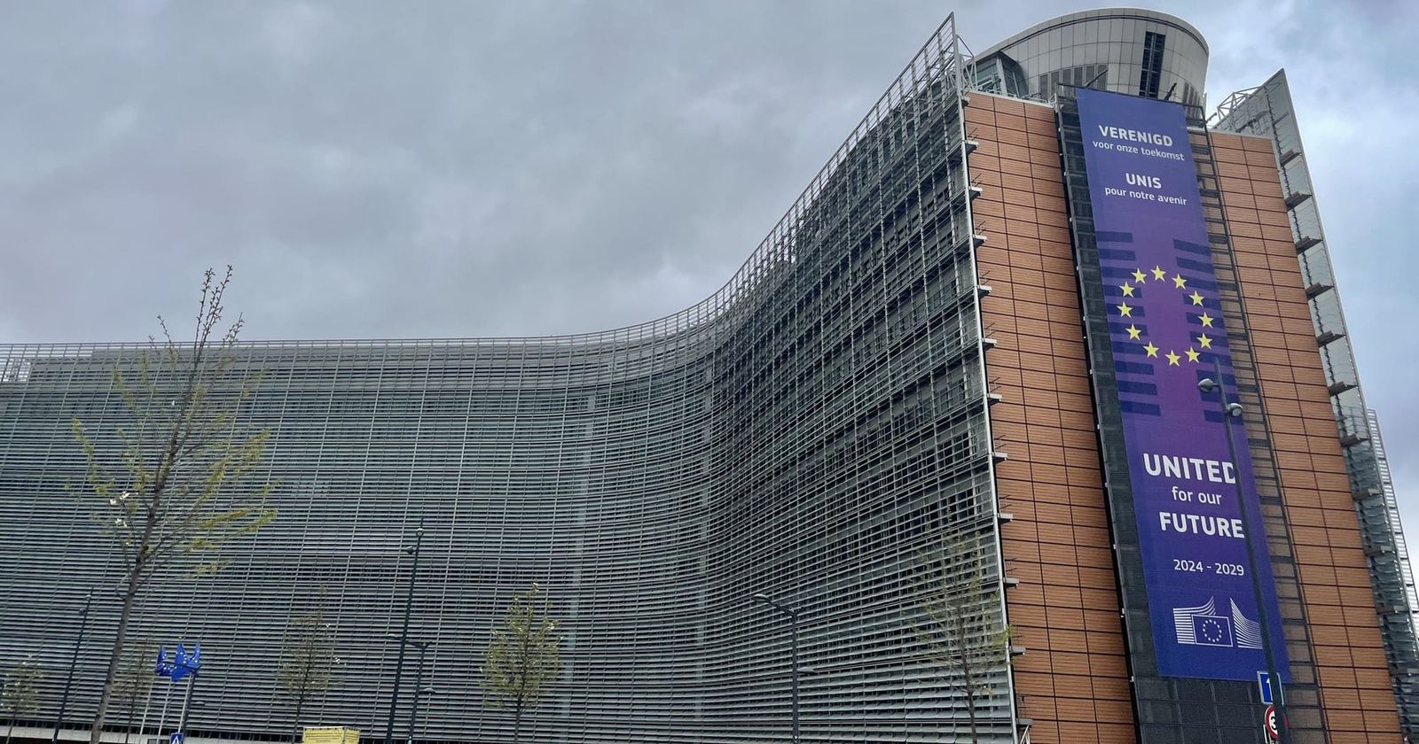 The curved facade of the Berlaymont building in Brussels, headquarters of the European Commission, with a Commission banner for its 2024 to 2029 term.