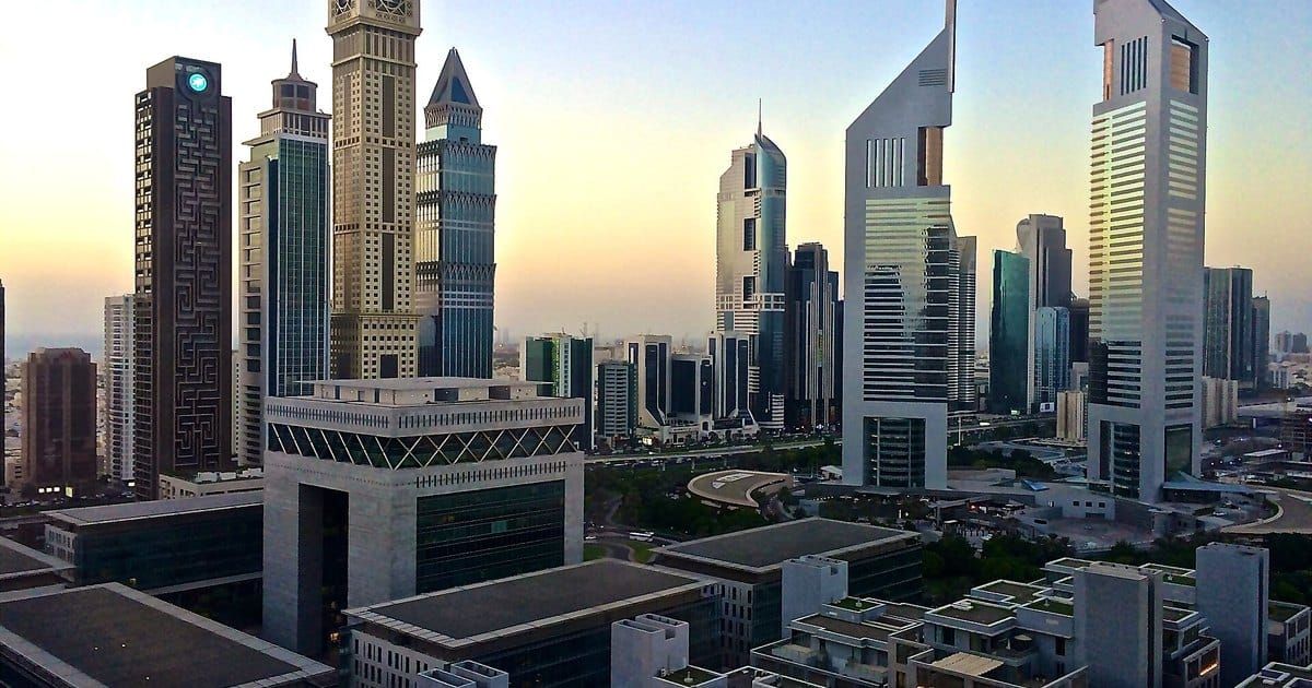 Los rascacielos del DIFC y las Emirates Towers de Dubái recortados contra el cielo al amanecer.