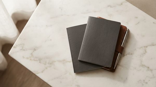 Two plain passport booklets on a marble surface, representing dual citizenship in 2026
