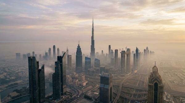 An aerial view of the Dubai skyline above a light haze, representing a Swiss founder setting up a Dubai company