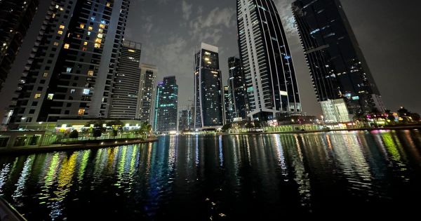 Towers of Jumeirah Lakes Towers, the DMCC free zone in Dubai, reflected in the lake at night.