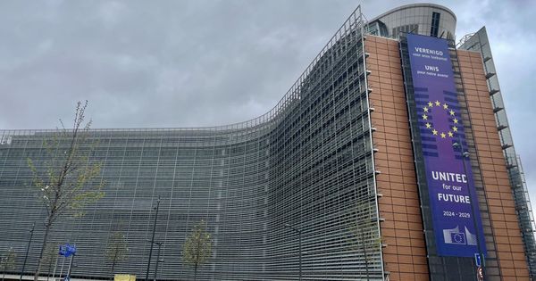 The curved facade of the Berlaymont building in Brussels, headquarters of the European Commission, with a Commission banner for its 2024 to 2029 term.