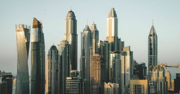 Die Hochhäuser der Dubai Marina stehen im warmen Abendlicht vor einem klaren Himmel.