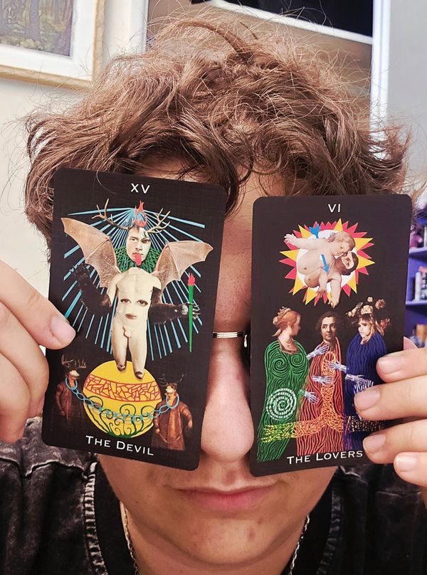 A selfie of me covering my bespectacled eyes using Moonlit Hermit Tarot's cards of The Lover and The Devil