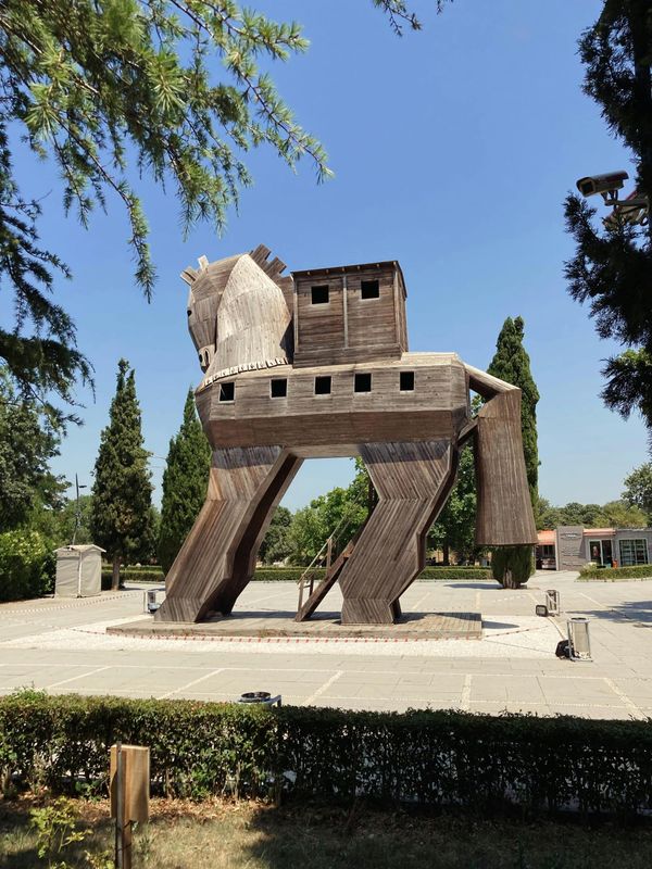 Wooden horse statue with stairs sitting in front of a government building