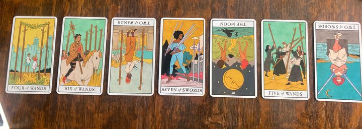 Seven tarot cards laid out in a line