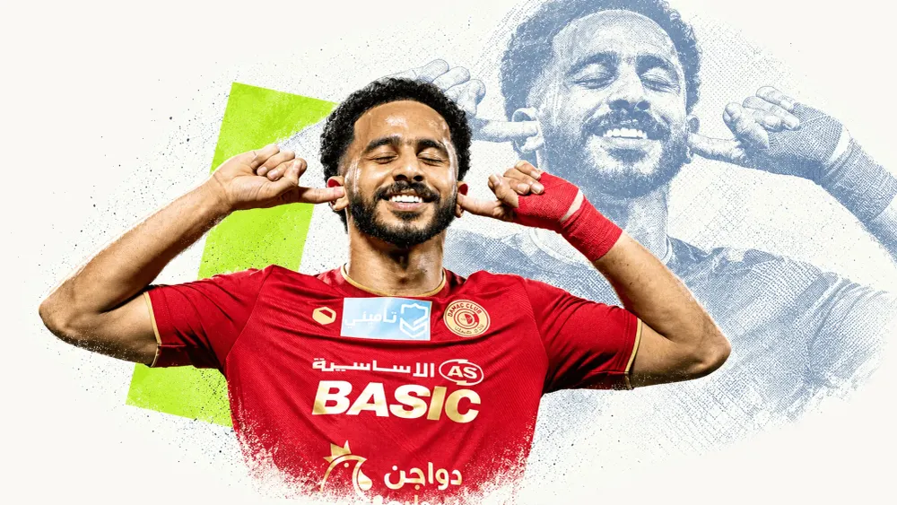 A footballer in a red shirt celebrates with fingers to his ears, accompanied by a blue-grey echo and green accent on cream.