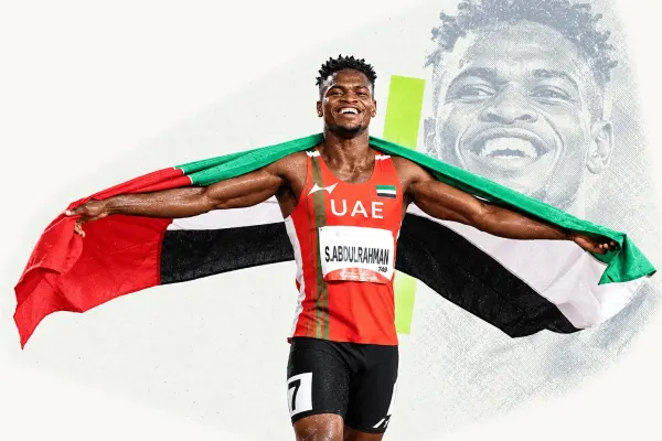 Editorial portrait of a UAE sprinter holding the national flag
