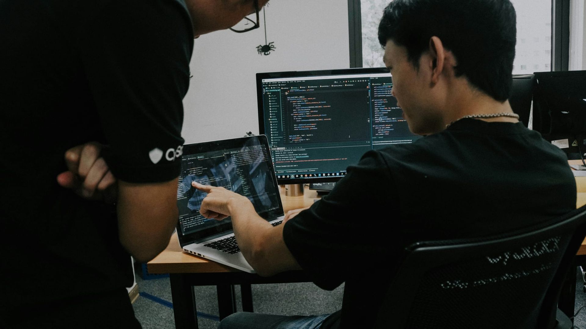 Two software developers working at desktop computers in an office - OpenAI models on Google Cloud