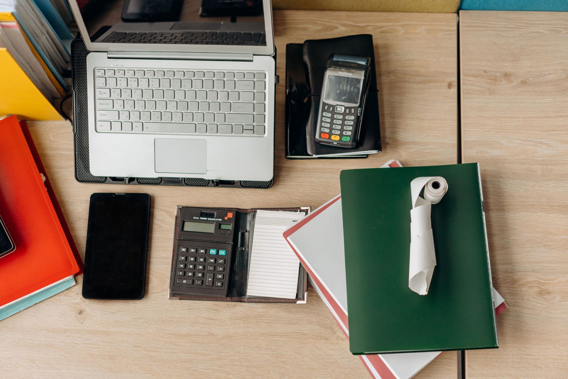 Office desk with a laptop, calculator, payment terminal and paperwork - 2025 fraud losses