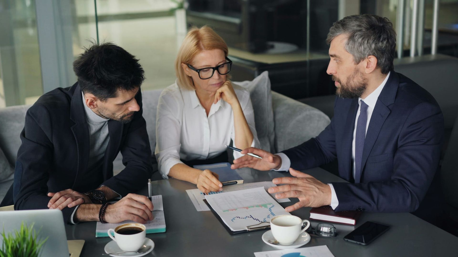 Business professionals reviewing documents together at an office table - SEC 2027 examination priorities