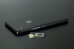 smartphone and SIM card arranged on a dark surface - mobile plan hidden fees