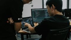 Two software developers working at desktop computers in an office - OpenAI models on Google Cloud