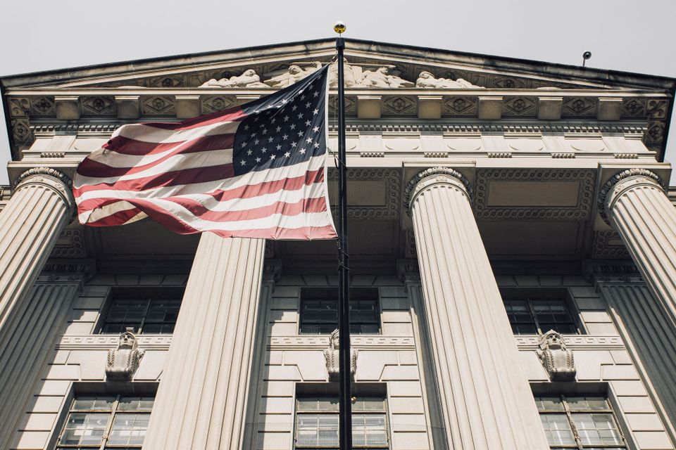 An American flag flying in front of a columned government building in Washington, D.C. - DHS DeepSeek order