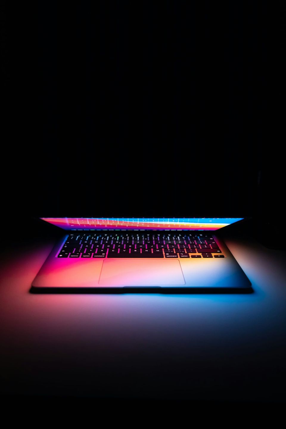 Close-up photograph of a backlit computer keyboard with illuminated keys
