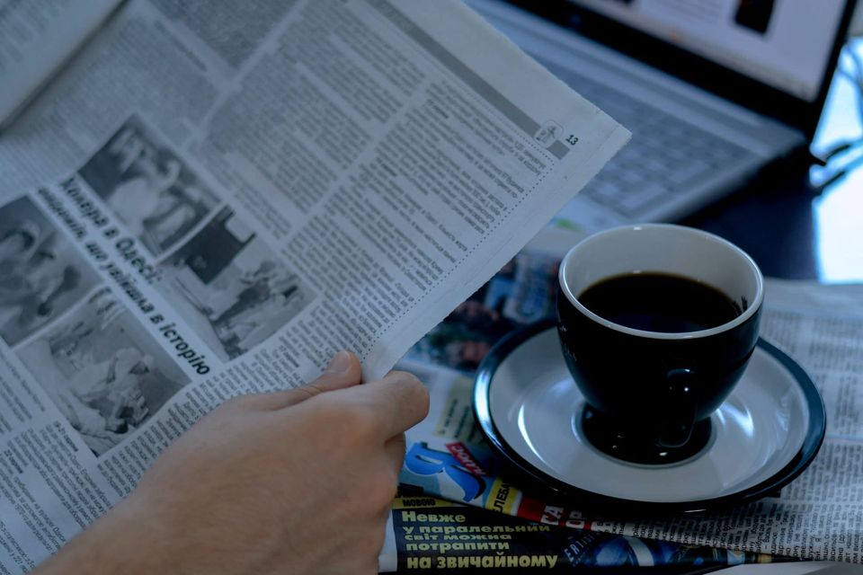 Laptop, coffee cup and newspaper on a desk - Meta commercial terms
