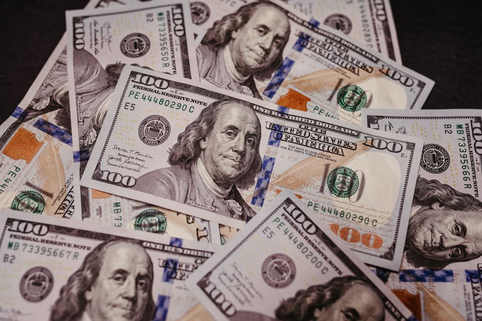 Close-up photograph of overlapping U.S. hundred-dollar bills - older adult fraud losses