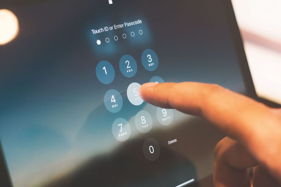 A hand types up a password on a smartphone screen- how to set up a passkey