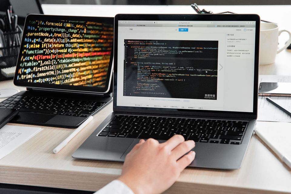 Developer working on a laptop displaying code in an office - Muse Wonder