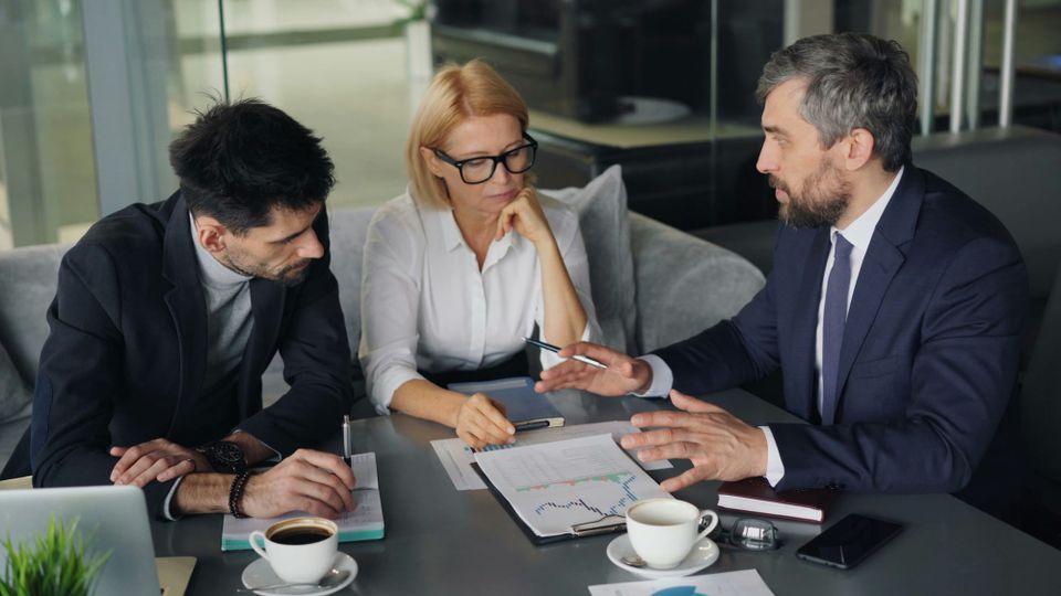 Business professionals reviewing documents together at an office table - SEC 2027 examination priorities