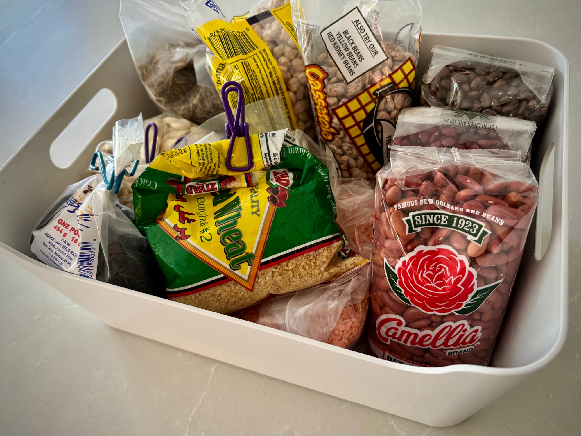 A bin filled with bags of beans and grains.